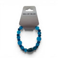 CCBeadsandBeyondLLC Sea Of Blue elastic bracelet with assorted blue glass beads and a striped focal bead.
